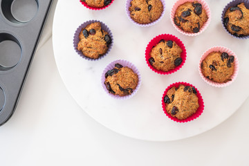Bran muffins with dry cranberries close up in baking silicon cups on white background. Healthy food, good source of dietary fiber
