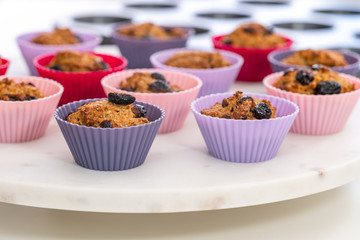 Bran muffins with dry cranberries close up in baking silicon cups on white background. Healthy food, good source of dietary fiber