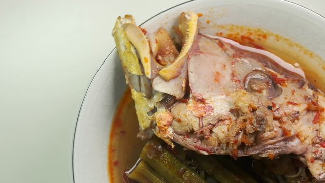 Flatlay rotating footage of red snapper "asam pedas" on turntable. "Asam pedas" is sour soup made from tamarind, chilli and spices that is popular in Malaysia and Indonesia.