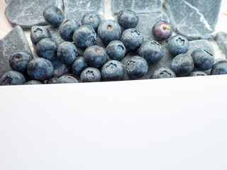 a bunch of large blueberries on a white sheet of paper for text