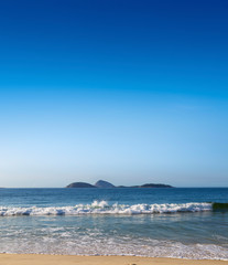 Fototapeta na wymiar Ipanema Beach. Rio de Janeiro, Brazil. Beautiful view of the beach, the sea and islands in front of the coast of Rio. For design, space in the sky for place text. Copy space.