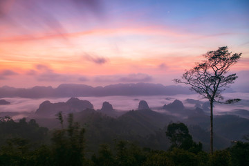 Scenic view of mountain and mist at sunrise.