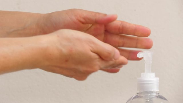 Woman hand push sanitizer bottle to pump alcohol gel and rubbing hand to clean to protect germ on pandemic, new normal lifestyle avoid of covid-19 flu endemic, squirt liquid of dispenser crane tap