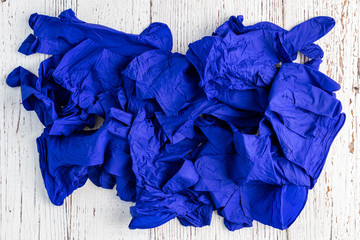Pile of dark blue nitrile protective gloves on a rustic white background
