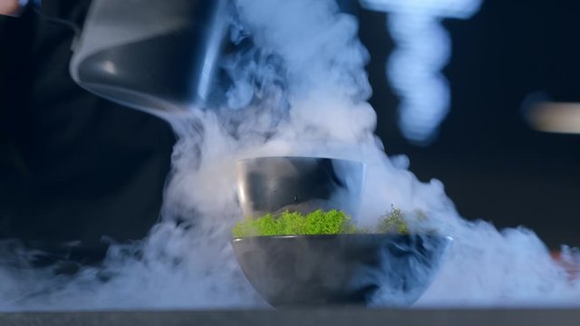 bartender is preparing an exclusive drink
chef sets smoky liquid nitrogen to make a drink for molecular cuisine
the cup is in the moss for the decoration cocktail
close-up shot 4.6K