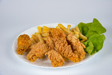 plate with french fries, crispy, fried meat, vegetables, juices and bread