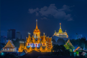 Naklejka premium Loha Prasat Wat Ratchanatda and Golden Mountain pagoda at night in Bangkok, Thailand.