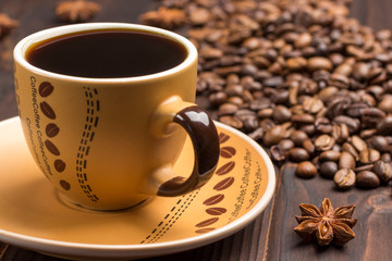 Coffee cup close up. Grains of coffee on table.
