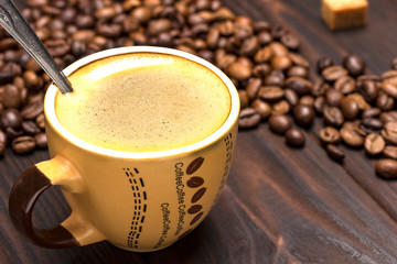 Coffee cup close up. Grains of coffee on table.