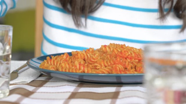 Woman eating fresh pasta with fork, close up