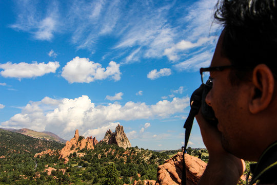 Close-up Of Man Photographing Rocky Mountains Against Sky At Colorado Springs