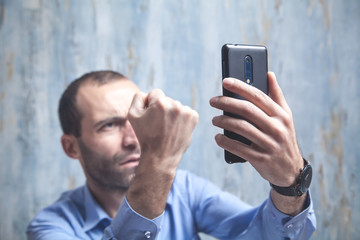 Angry caucasian businessman with smartphone.