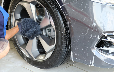 Closeup of grey car cleaning, washing and rubbing to remove dust and dirty things by male worker's...
