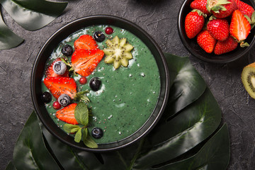Colorful, healthy food. Acai smoothie bowl. Keto breakfast idea. Fruit curd smoothie, acai. Breakfast with green spirulina, strawberry, chia, kiwi in black plate
