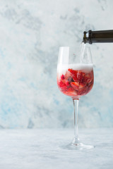 Glass with ice Summer homemade Cold red sangria cocktail with strawberry  in glass on blue  background. Concept of vacation, summer