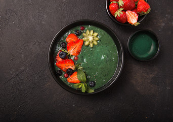 Colorful, healthy food. Acai smoothie bowl. Keto breakfast idea. Fruit curd smoothie, acai. Breakfast with green spirulina, strawberry, chia, kiwi in black plate