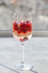 Glass with ice Summer homemade Cold red sangria cocktail with strawberry  in glass on blue  background. Concept of vacation, summer