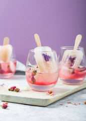 Color food. Cocktail glasses of pink rose champagne, or lemonade with dry rose buds, ice-cream