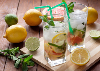 Summer refreshing drink with ice. Three types of citrus lime, lemon, pink grapefruit. Natural citrus lemonade with mint.