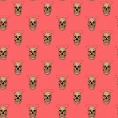 Skull with jaw on a pink seamless pattern. A human skull replica with separated jaw located in rows on a pink background. Square seamless background pattern from geometric shapes. 