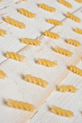 Spiral pasta on a white wooden background. Background for cooking and food.