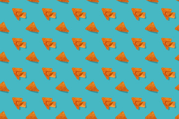 Nacho seamless pattern on blue background. Nacho Cheese Flavored Tortilla Chips in a rows on blue background. Tortilla chips or nachos tortillas. Traditional mexican fast food.