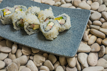 Japan gourmet cuisine - closeup detail on delicious and delicate dish of Japanese sushi rolls in slate on stone bg in traditional healthy Asian food and creative oriental dining