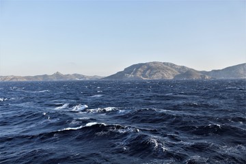 An island in the middle of the sea is deserted, its hills and peaks are visible from afar.
