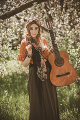 Gypsy woman with guitar at field, lifestyle, ideas for costume on Halloween