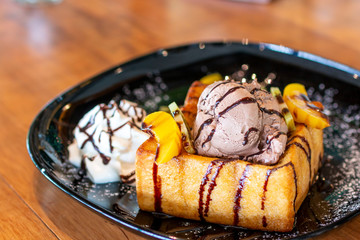 Toasted bread and chocolate ice cream with fruits topping. Chocolate  Ice cream with toasted bread on plate. Ice cream with toasted and chocolate topping in Coffee shop.