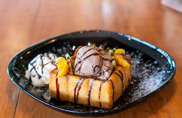 Toasted bread and chocolate ice cream with fruits topping. Chocolate  Ice cream with toasted bread on plate. Ice cream with toasted and chocolate topping in Coffee shop.