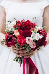 Bride holding bouquet , wedding details, red colour, marsala