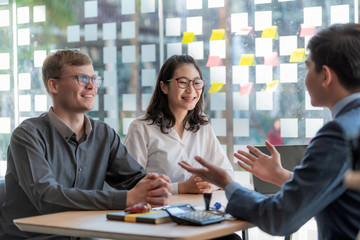 Young asian business people in smart casual wear at meeting discussing new business project to his partner in office.