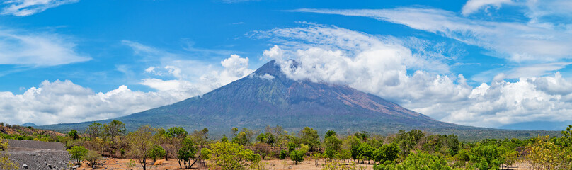 Mt. Agung covered with clouds in front of the blue sky in Bali