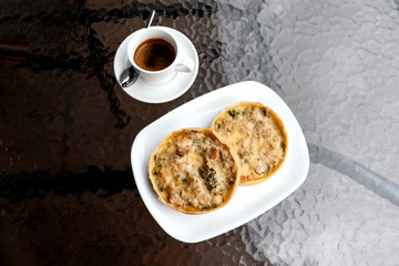 Bakery, chicken pie and broccoli, espresso coffee on cafe table.