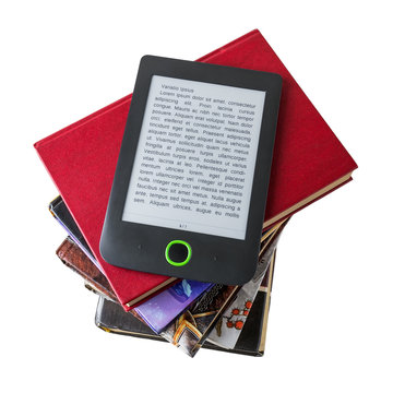 E-book reader on a stack of paper books isolated on white background. Copy space on e-book display. E-reading for pleasure and education.