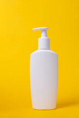 Mock-up plastic bottle with dispenser. Yellow background.