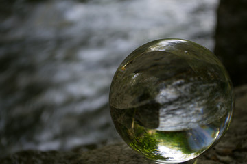 Auf dem Foto ist zu sehen, eine klare Kristallkugel, die mittels verschiedener Abstand- & Fokus-Einstellungen, unterschiedliche Bilder erzeugt.

Das Foto wurde auf der Donauinsel, in Österreich aufg  