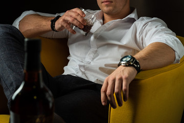 brutal man holds a glass of whiskey in his hands