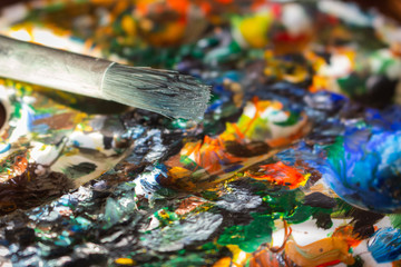 Dirty palette board. Bright acrylic paints close up. Drawing concept. Palette and brush. Watercolor...