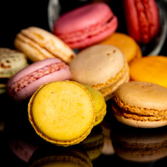 Gros plan de macarons multicolores sur fond noir