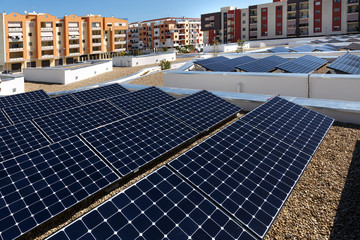 Pannelli fotovoltaici sopra il tetto di un palazzo, intorno altri palazzi