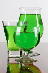 Glass jars with green cocktails on table