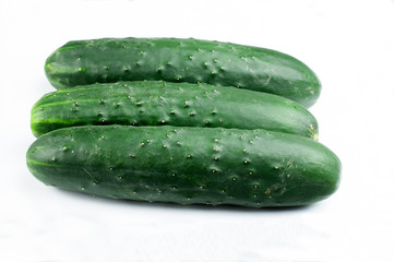 a group of three cucumbers on white background