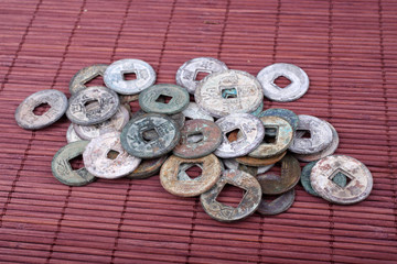 Ancient Chinese coins on bamboo background