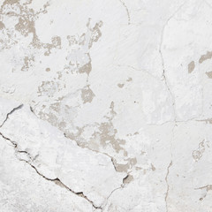 Naklejka premium the background of the cracked white wall of the house is old covered with plaster and the paint is peeling from time. Very old house. cracks in the wall