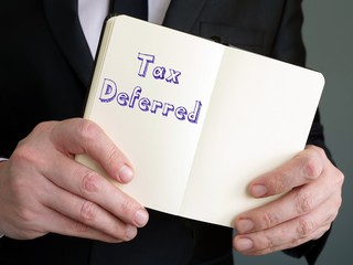 Financial concept meaning Tax Deferred with phrase on the piece of paper.