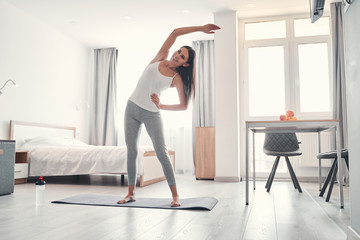 Fototapeta na wymiar Positive delighted young woman doing morning exercise