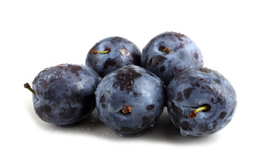 Black plums isolated on white
