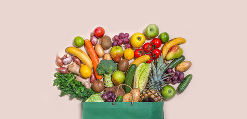 Grocery, paper bag with healthy, different fruits and vegetables on a light background. The concept of a grocery supermarket. Healthy eating Vegan. Flat ley